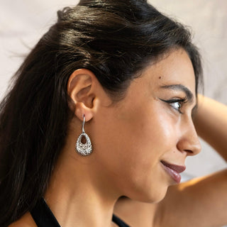Model wearing the Lace Drop sterling silver earrings by Nile & Nova, featuring a delicate floral-inspired design.