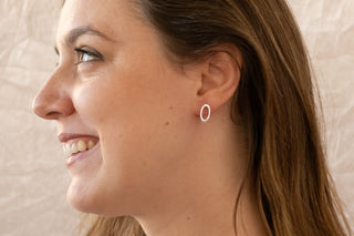 Sterling silver open oval stud earrings worn by smiling model in side profile by Nile & Nova