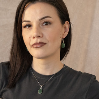Sterling silver Selva necklace with green oval pendant worn by model in black top by Nile & Nova