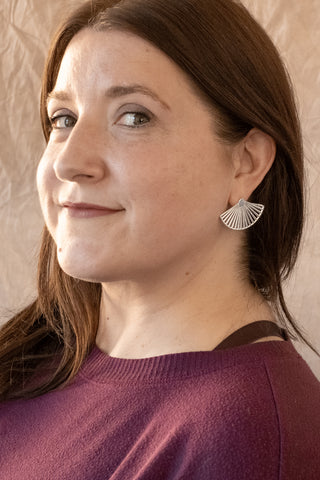 Model wearing Nile & Nova’s Soleil earrings — sculptural sterling silver fans that catch the light beautifully.