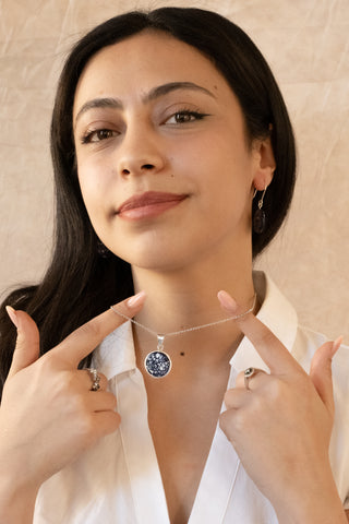 Sterling silver Celest necklace with marbled blue stone pendant worn by model in white blouse by Nile & Nova