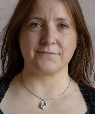 Model wearing the Lace Drop Necklace featuring an intricate sterling silver teardrop pendant.