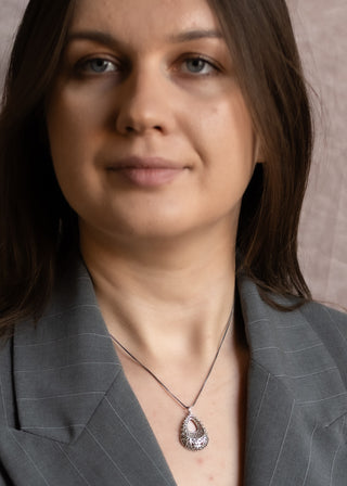 Model styling the Lace Drop Necklace with a grey blazer and elegant silver detailing.