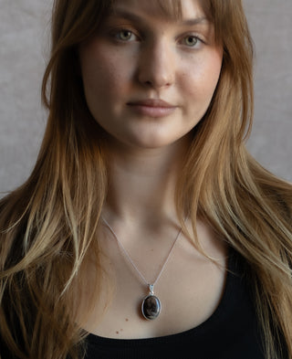 Woman with long strawberry blonde hair wearing the nile and nova brown pendant necklace. 