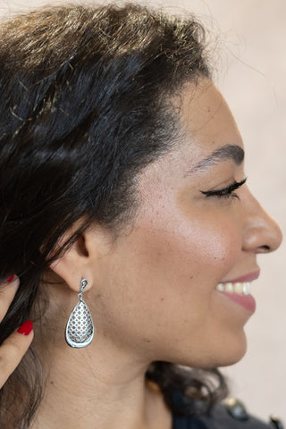 Model showcasing the Mashrabiya sterling silver earrings from Nile & Nova, featuring elegant lattice-style craftsmanship.