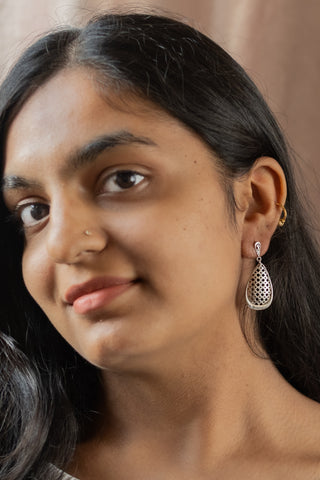 Model wearing the Mashrabiya earrings by Nile & Nova, sterling silver drops inspired by Arabic lattice design.