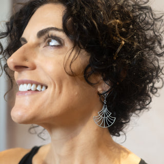 Model wearing the Nocturne silver teardrop earrings by Nile & Nova, smiling with soft natural light.