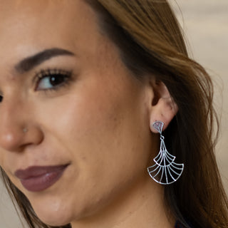 Model gazing upward wearing the Nocturne statement earrings in polished silver from Nile & Nova.