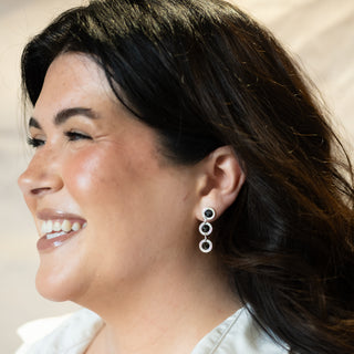 Close-up of model smiling in soft light while wearing the Orbit silver earrings by Nile & Nova.