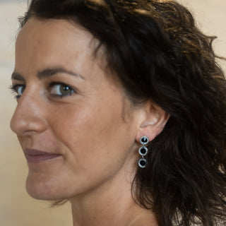 Model wearing Nile & Nova’s Orbit earrings in sterling silver — elegant triple-circle drop design.